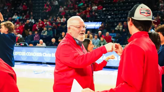 John Hardt fist bumps a student during a procession