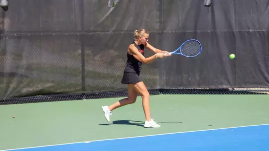 Lainey O'Neil hitting a ball back across the court