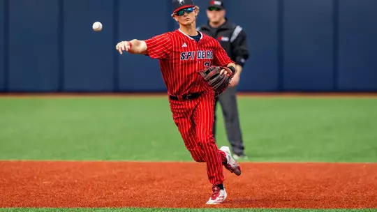 Noah Haught throws the ball towards first base from short stop