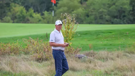 Adam Decker walks near a green