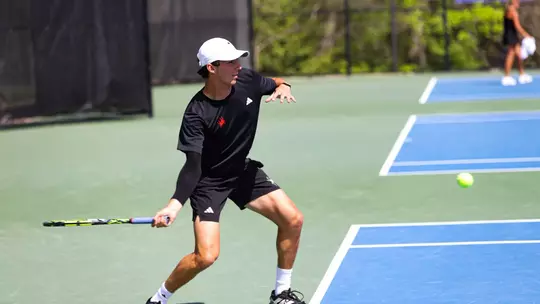 Grant Cohen hitting a ball back across the court