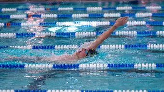 Jackson Kogler swimming the backstroke at the Front Range Invite