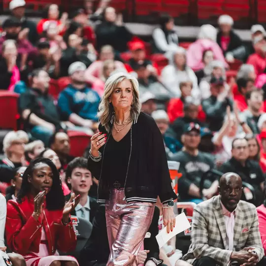 Head Coach Krista Gerlich stands on the sideline in front of the Texas Tech bench and watches the team score.