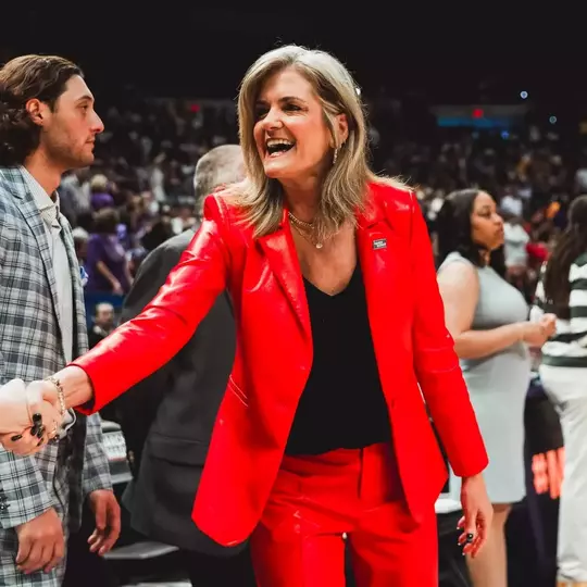 Krista Gerlich shaking hands with the opposing team's coaches.