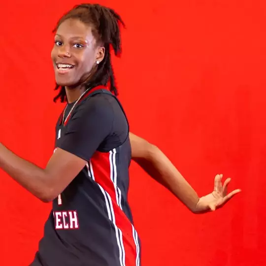 Jalayah Ingram tossing a basketball behind her in a photoshoot.
