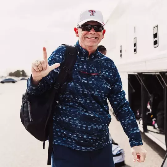 Wes Kittley throwing the guns up sign before getting on a bus