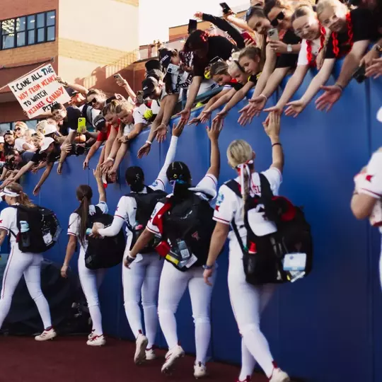 Texas Tech softball players are greeted by fans at the Women's College World Series.