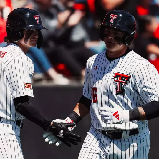 Matt Quintanar (26) and Kyeler Thompson (2) exchange a handshake during the Red Raiders Apr. 4 contest against Houston