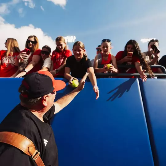 Gerry Glasco high-fiving fans as we walks onto the field at the WCWS