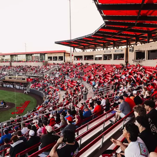 The sun dips lower in the sky at Rip Griffin Park during a 2026 crowd shot from the stands during a baseball game