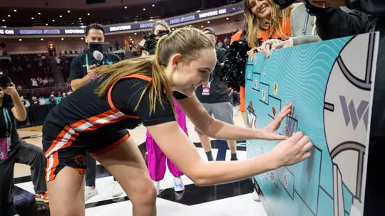 Ally Schimel puts the sticker on the bracket after being LMU