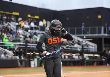 Mya Harrison grabbing her helmet as she walks back to the dugout.