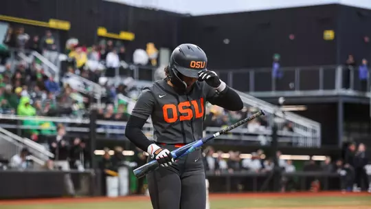 Mya Harrison grabbing her helmet as she walks back to the dugout.