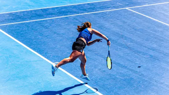 Carla Grignac following through a serve