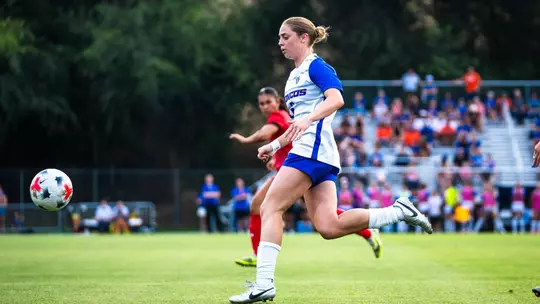 Mia Lane running after the ball.