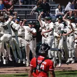 Noah Bright and team celebrate outside dugout