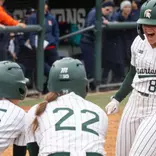 Sophie Holverstott is greeted by teammates at home plate