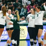 Volleyball celebrates in a huddle against UCLA
