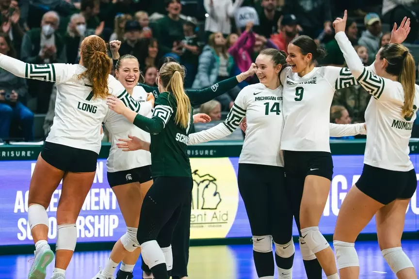 Volleyball celebrates in a huddle against UCLA