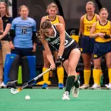 Caro Schafer hits the ball against Michigan at Ralph Young Field