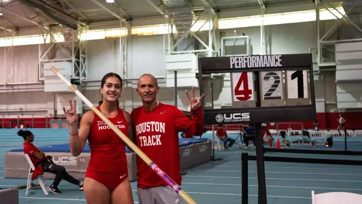 Evina Panagiotou stands next to sign reading 4.21m with Kyle Tellez after setting the indoor pole vault school record