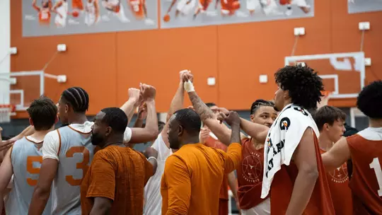 men's basketball end of practice team huddle image