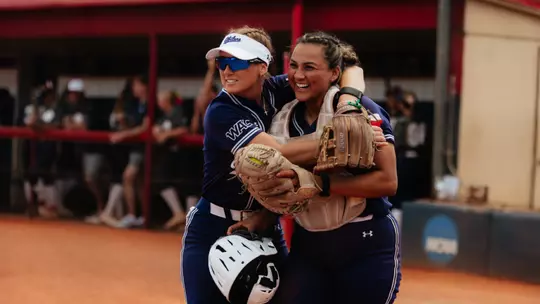 Emalee Romero hugs catcher Valerie Ornelas after an impressive catch in foul territory during a game at Utah Tech on May 1, 2026