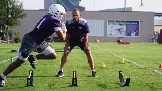 Trae Hill runs a drill with running backs coach Clark Harrell motivating on July 29, 2026