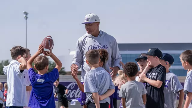 Joel Filani talks with campers at a youth football camp put on by ACU.