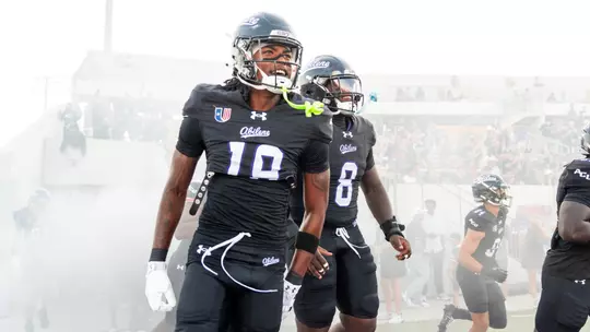 MJ Harrell (left) and Alex Bowman Jr. (center) run onto the field before ACU's game against Stephen F. Austin on Sept. 12, 2026