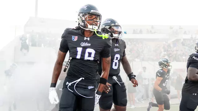 MJ Harrell (left) and Alex Bowman Jr. (center) run onto the field before ACU's game against Stephen F. Austin on Sept. 12, 2026