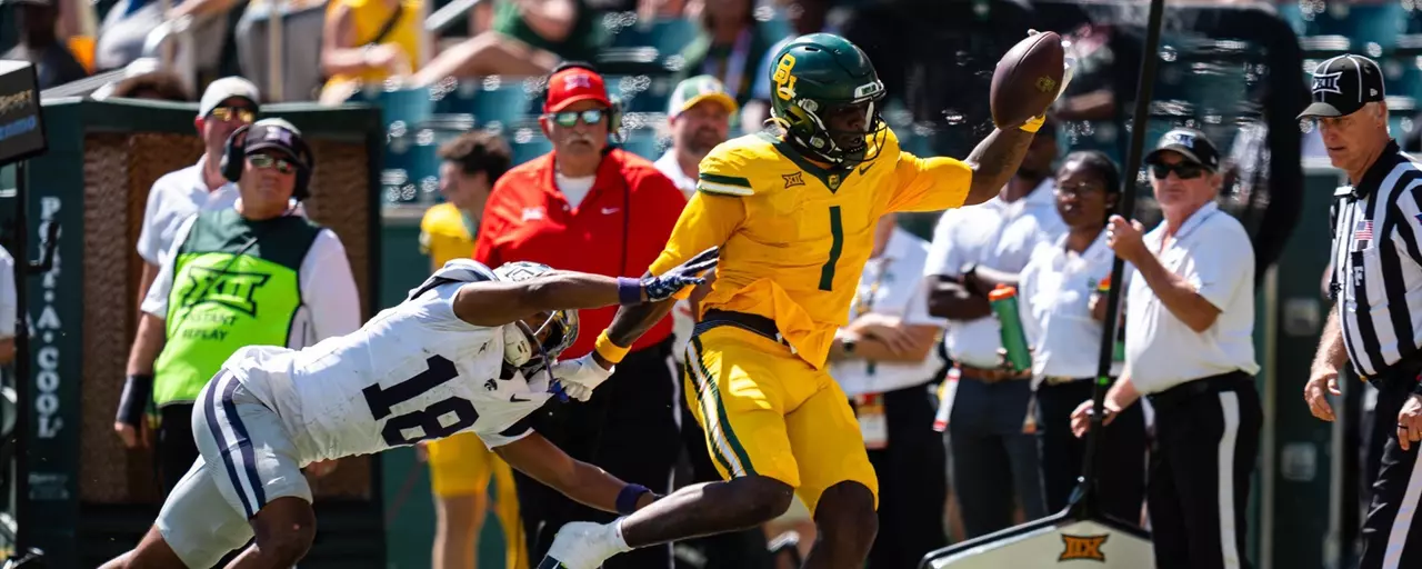 Action shot of Michael Trigg catching a football against K-State