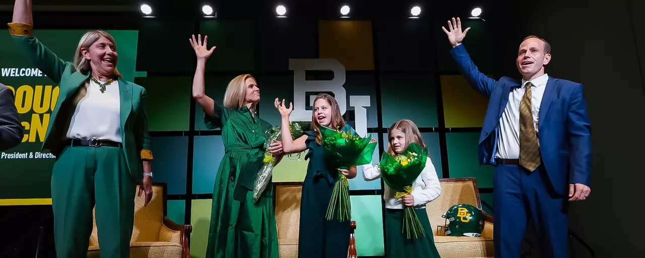 Dr. Livingstone and McNamee Family with their hands raised doing a Sic 'Em