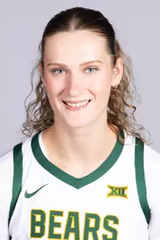 Kate Koval headshot 2026 in front of a white backdrop with a white uniform