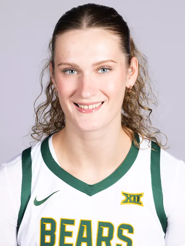 Kate Koval headshot 2026 in front of a white backdrop with a white uniform