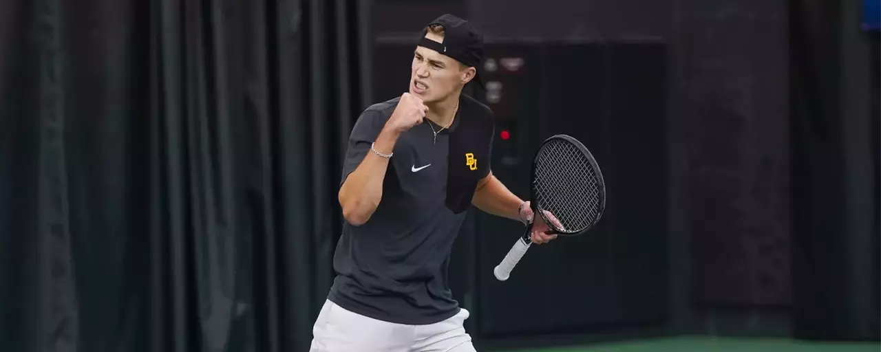 Tennis player Luc Koenig cheers with a fist bump in the air after a point during a home match