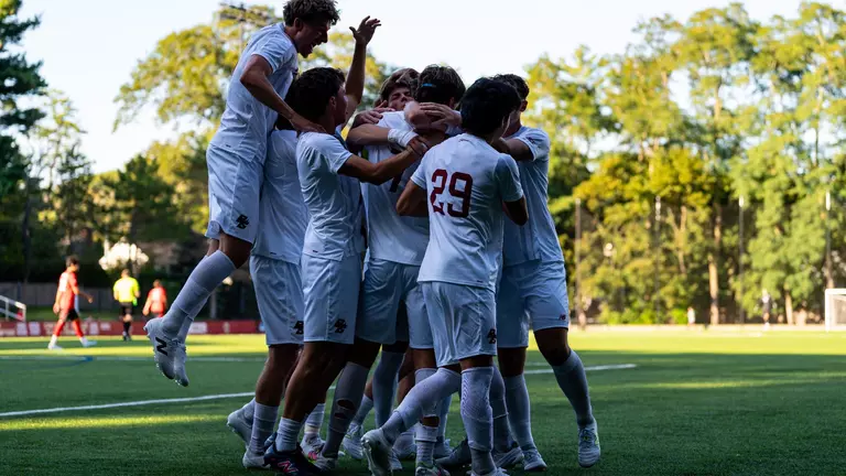 Men's Soccer celebrating goal against Northeastern