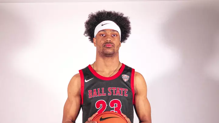 Kai McGrew wearing a white headband and black Ball State basketball uniform