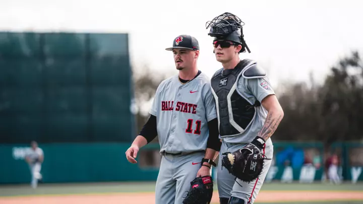Luke Reed and DJ Scheumann in grey Ball State baseball uniforms walking off the field