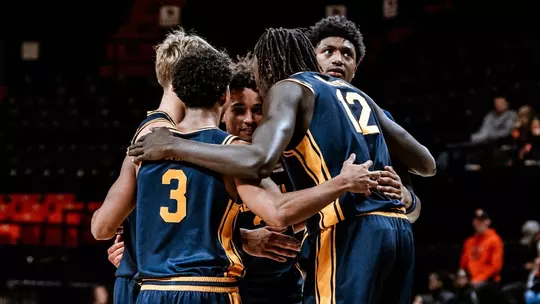 Cal players huddle up during an exhibition game at Oregon State