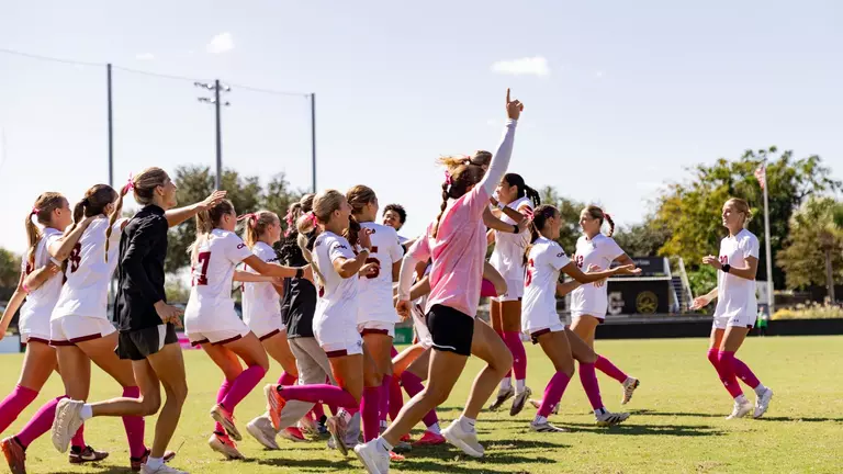 Women's Soccer running onto field