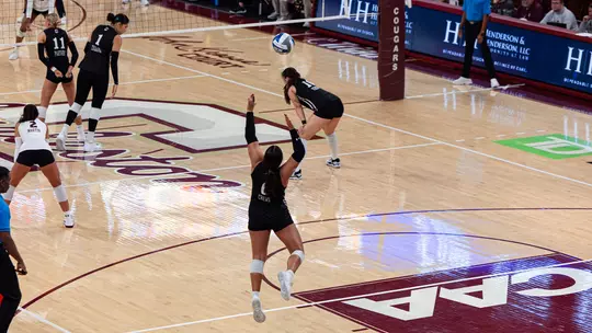 Cole Crews serving a volleyball in TD Arena.