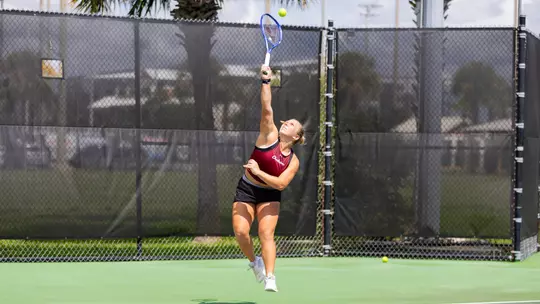 Marra Bruce reaching up to hit the tennis ball