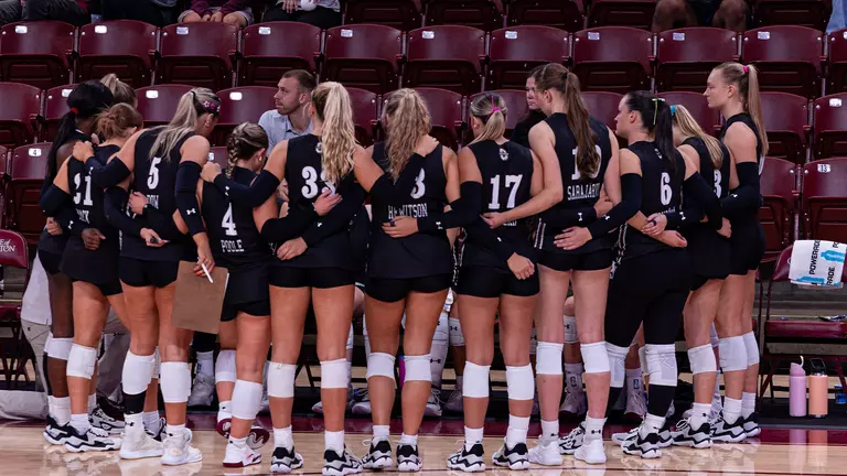 Charleston volleyball team huddle during a timeout.