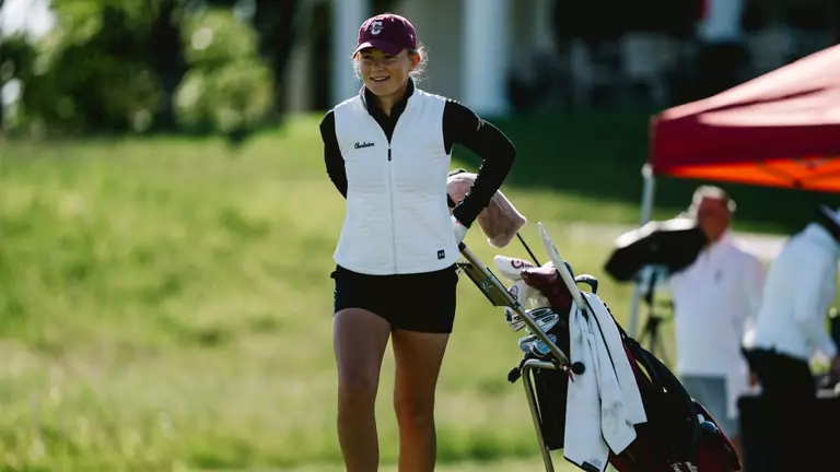 Emilie von Finckenstein walks her clubs to the next hole