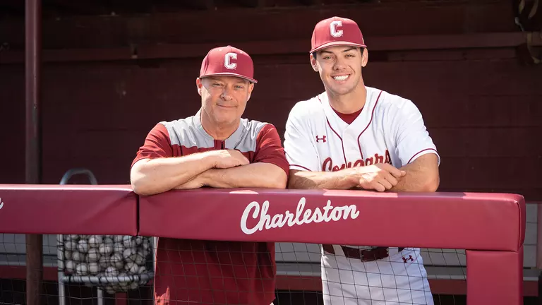 Chad and Reece Holbrook posing for a photo in the dugout at Patriots Point.
