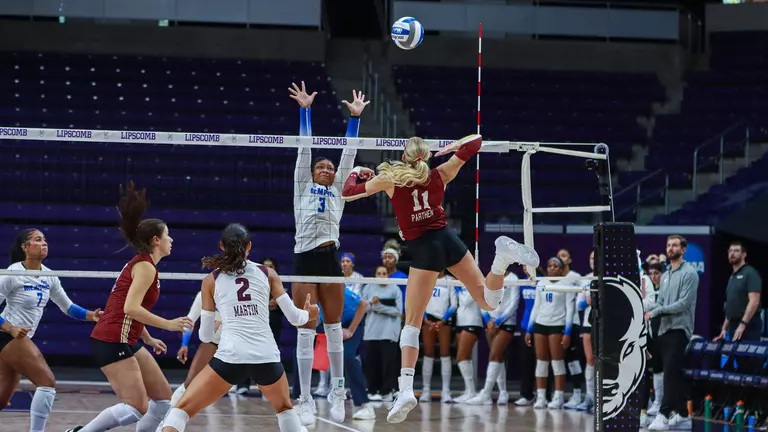 Makena Parthen readying to hit a volleyball vs Memphis.