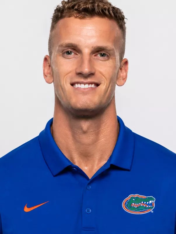 Man smiles in front of white background for head shot