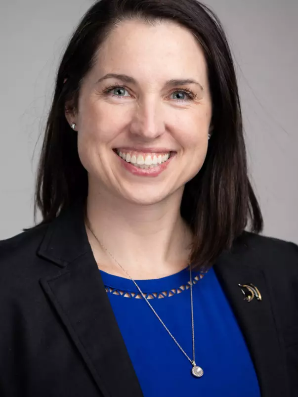 A brunette woman smiles for a head shot