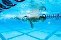 Swimmer fully submerged in middle of race